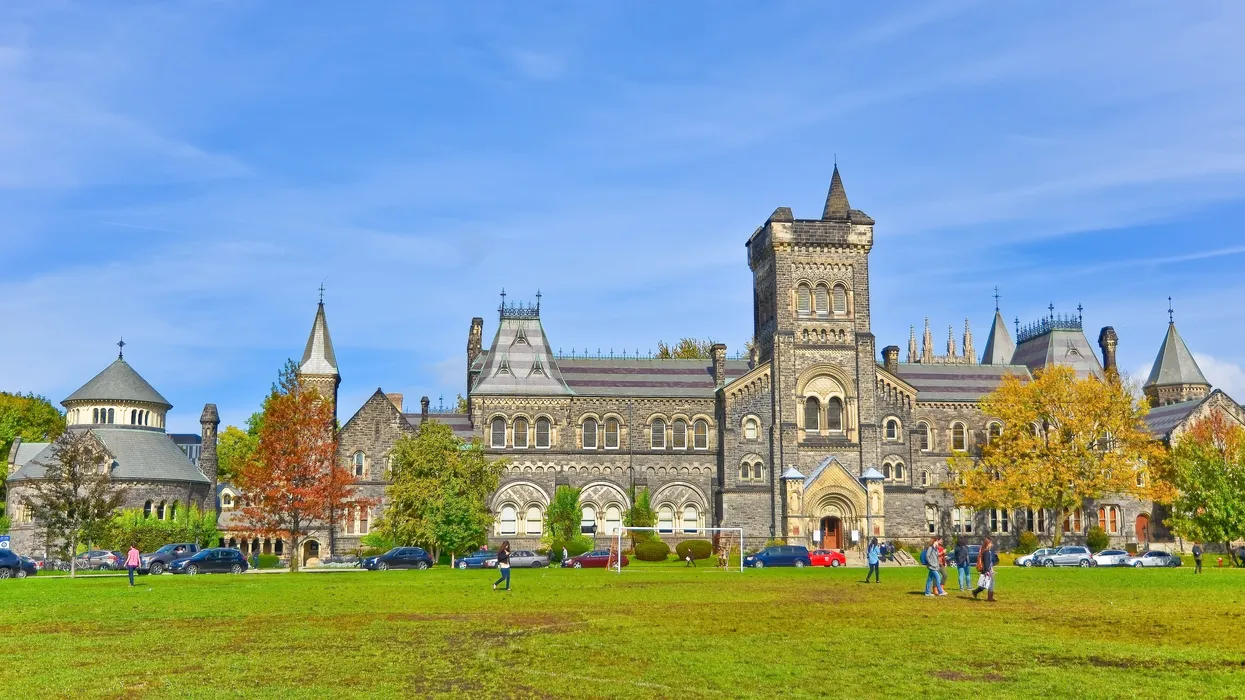 a-gothic-style-university-campus-building-with-a-soccer-field-out-front